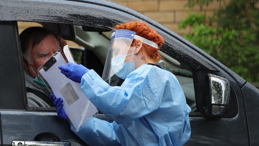 A man in his car getting a COVID-19 test