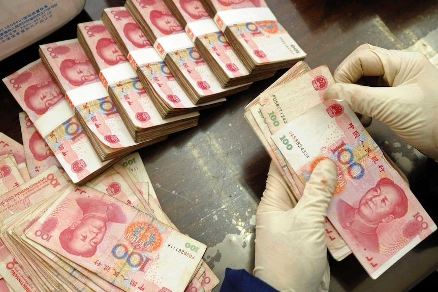 Bank of China employee counts yuan banknotes