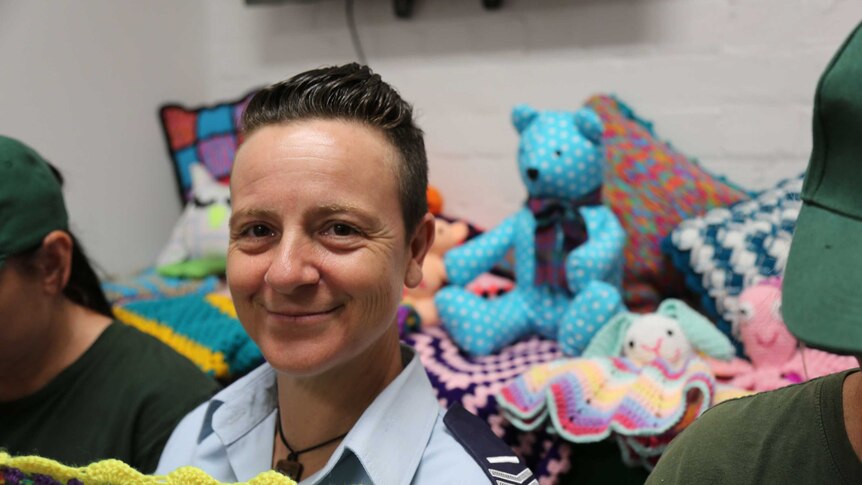 Rachel Fodera sits between two inmates crocheting