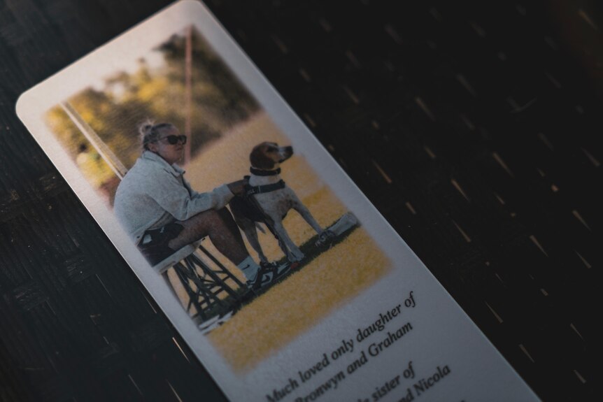 A bookmark with a photo of a woman sitting and petting a dog