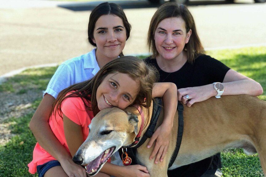 Justine Giles and her two daughters with their dog.