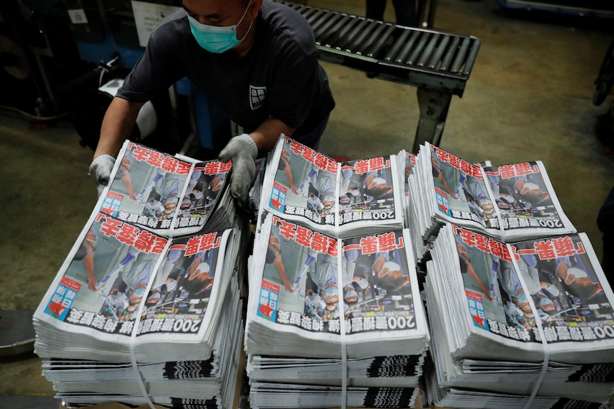 Bundles of Apple Daily are kept in piles with the defiant headline 'Apple Daily will fight on' after Lai's arrest