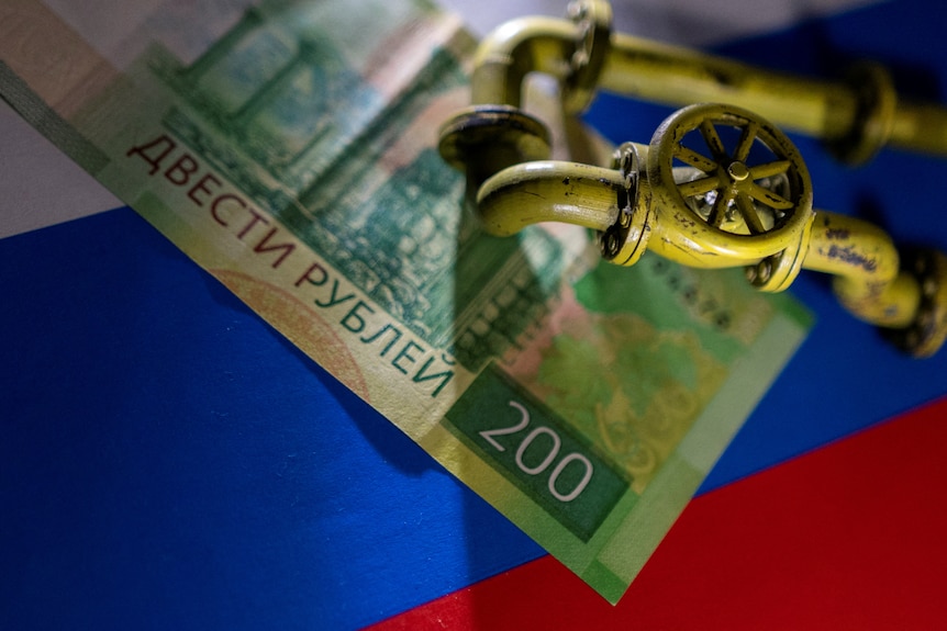 天然气管道的模型被放置在俄罗斯卢布钞票和国旗上。