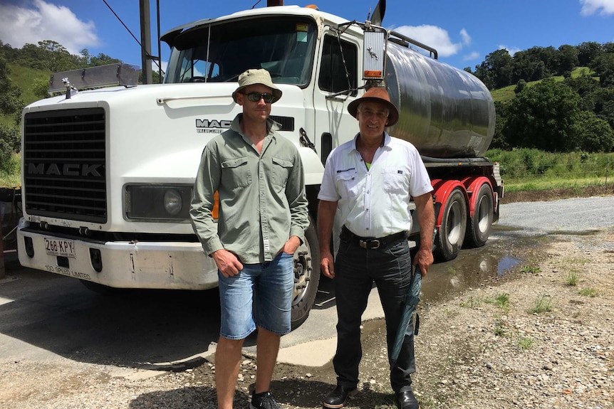 Matthew (l) and Larry Karlos standing in front of water tanker