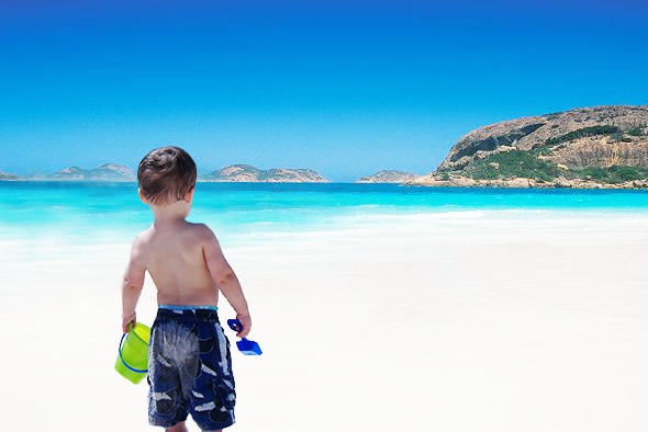 A toddler stands on the white sandy beach at Lucky Bay near Esperance.