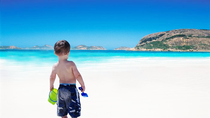 A toddler stands on the white sandy beach at Lucky Bay near Esperance.