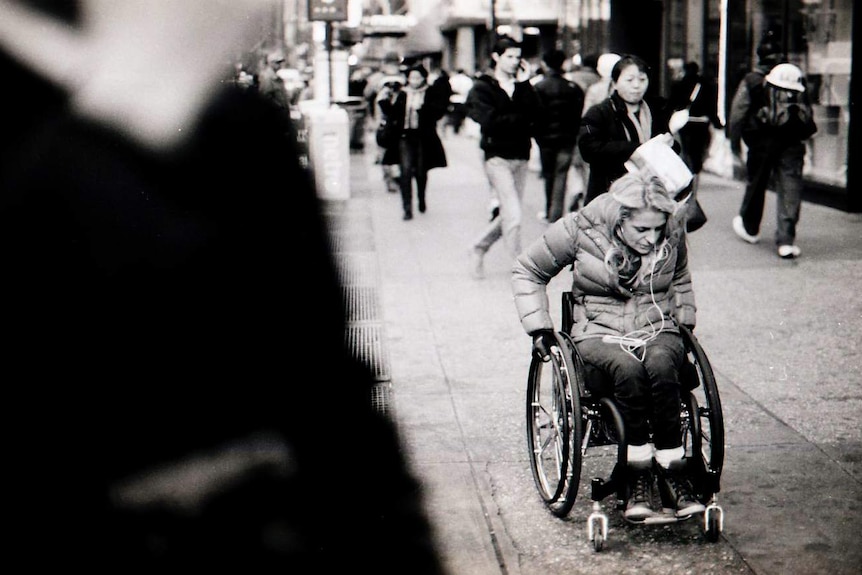 Woman in a wheelchair on a busy street