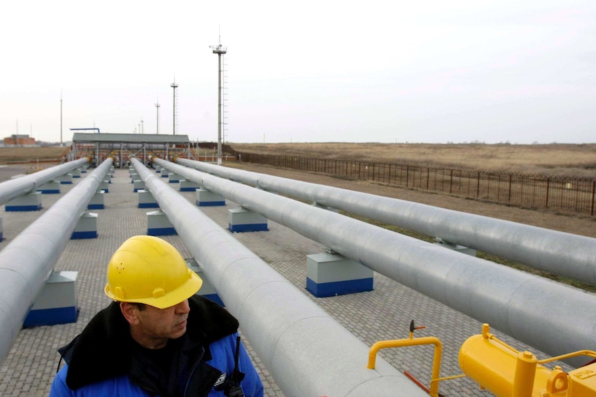 一名俄罗斯天然气工业股份公司的工人在俄乌边境的一个燃气计量站走过管道。