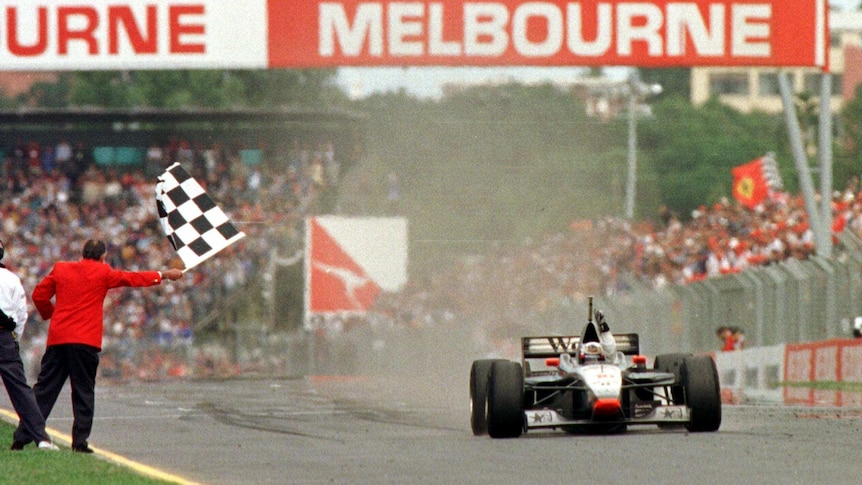 Sir Jack Brabham waves the chequered flag at the end of the 1997 Australian Grand Prix.
