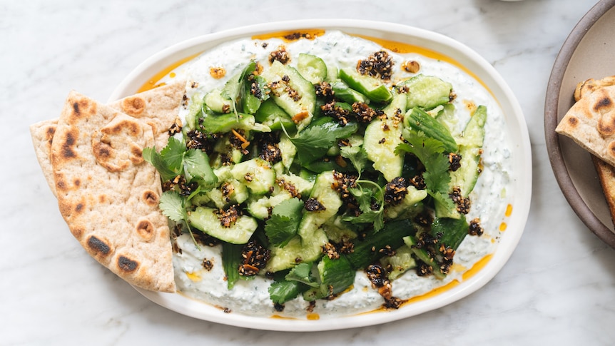 A photo showing Hetty McKinnon's smashed cucumbers with yoghurt and chilli crisp.