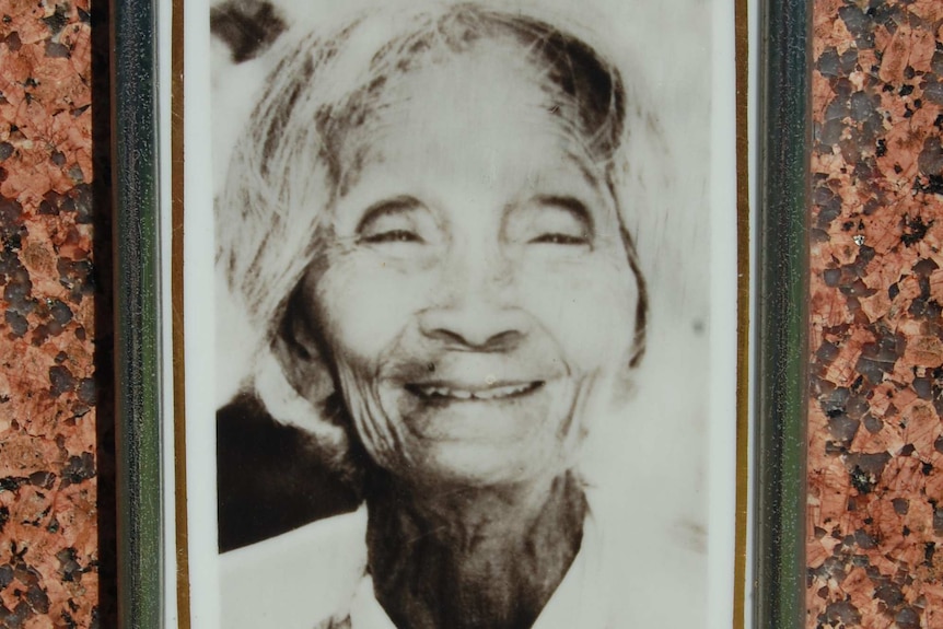 Black & white in a silver frame mounted on a polished granite headstone of an elderly Chinese lady