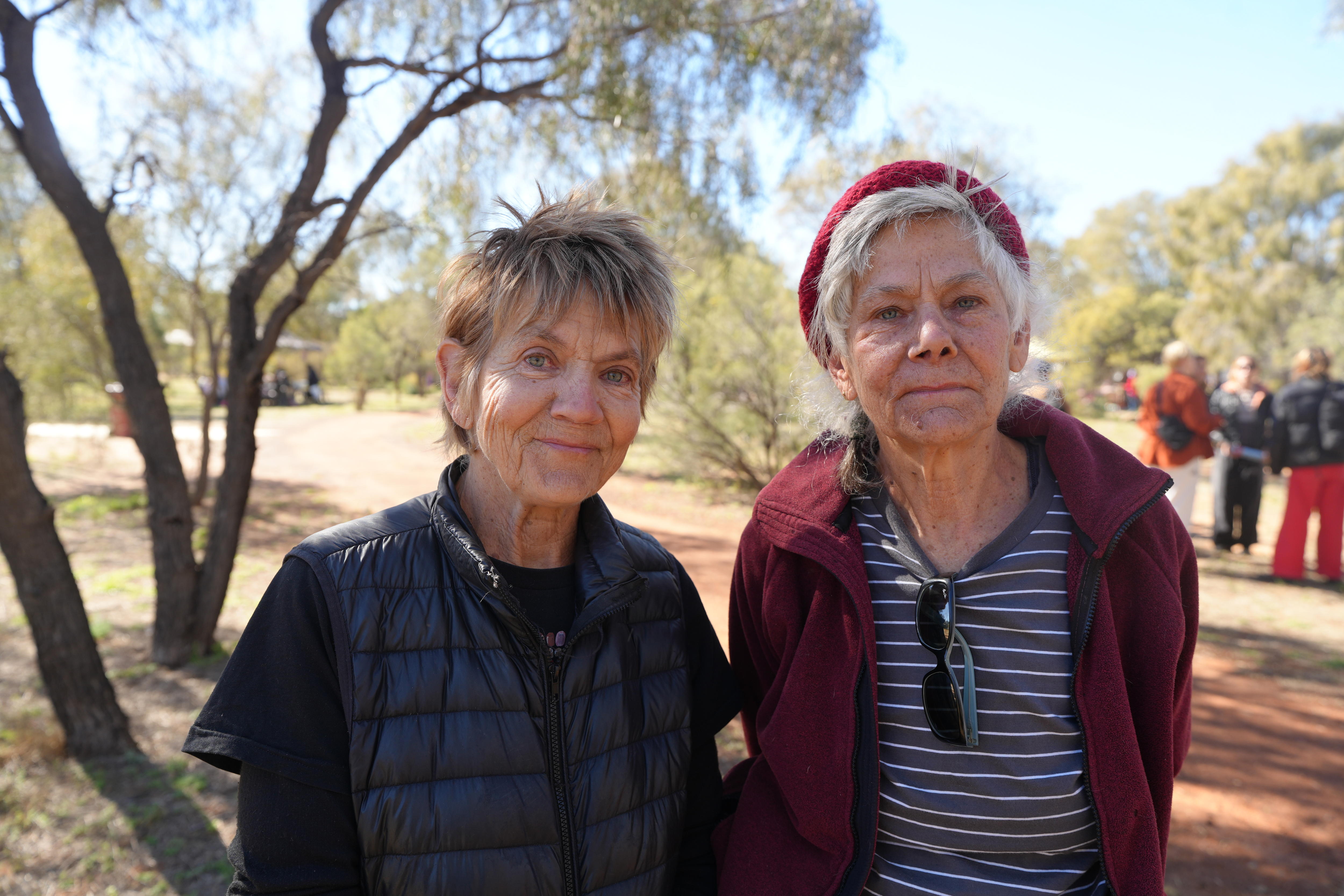 Two older women smile for the camera.
