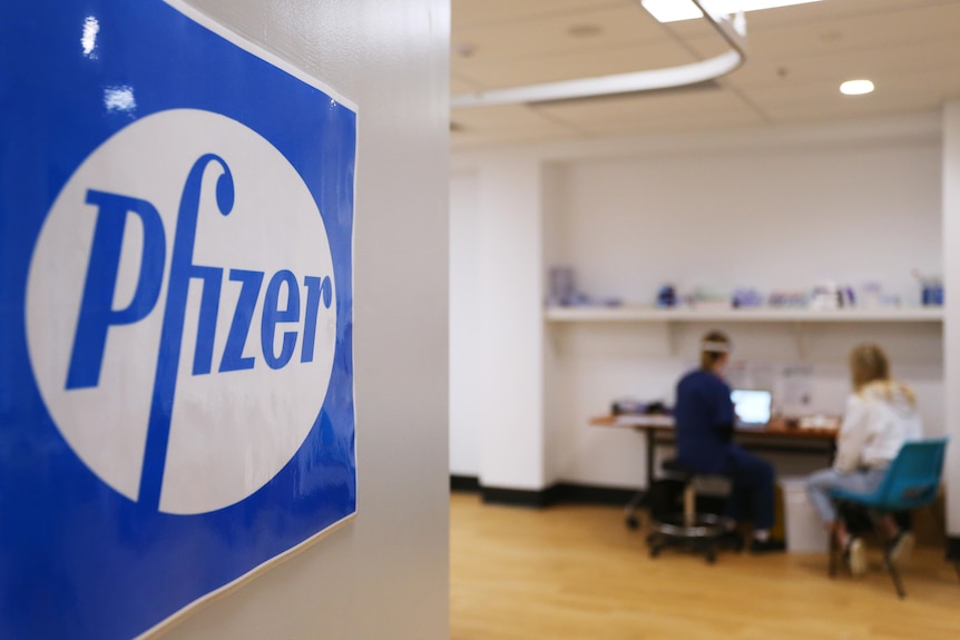 Pfizer sign on door with people in background