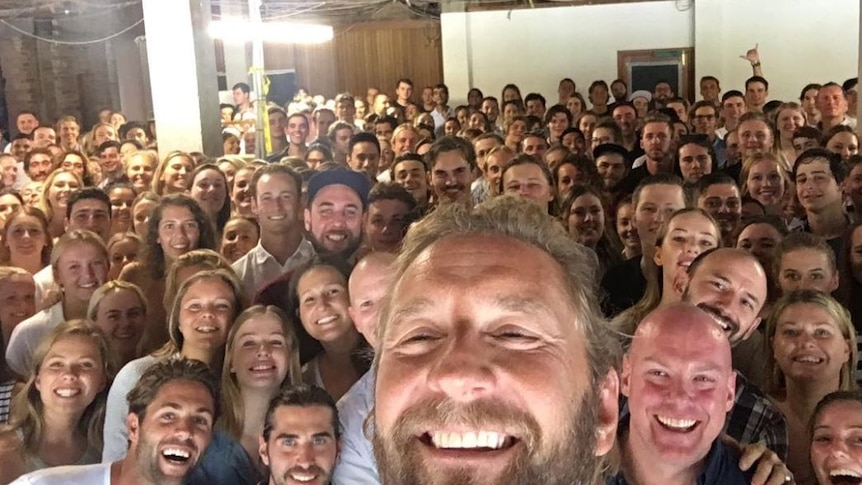 A large group of people smile for the camera