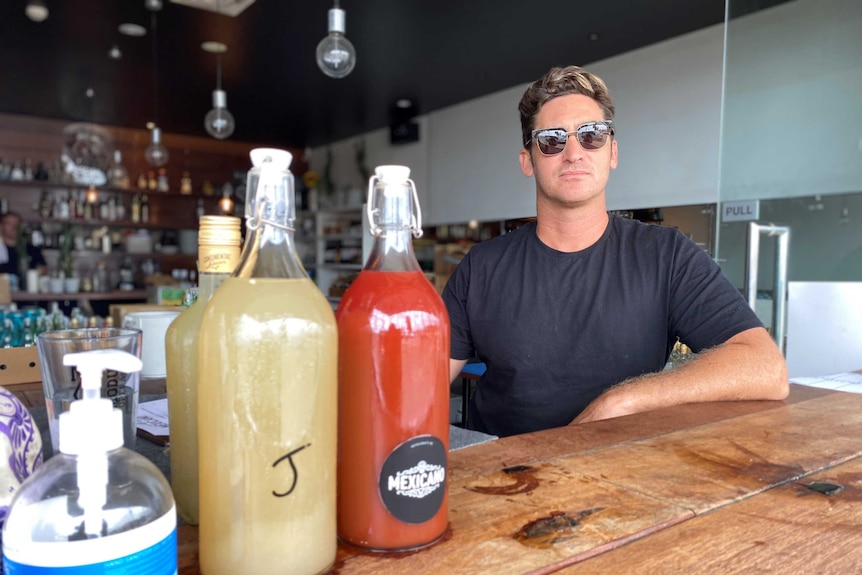 a man in sunglasses next to some cocktail bottles