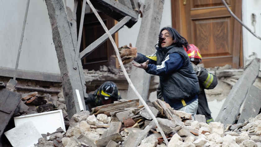 Rescue workers look for survivors in the ruins of a collapsed house.