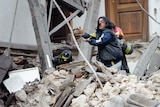 Rescue workers look for survivors in the ruins of a collapsed house.