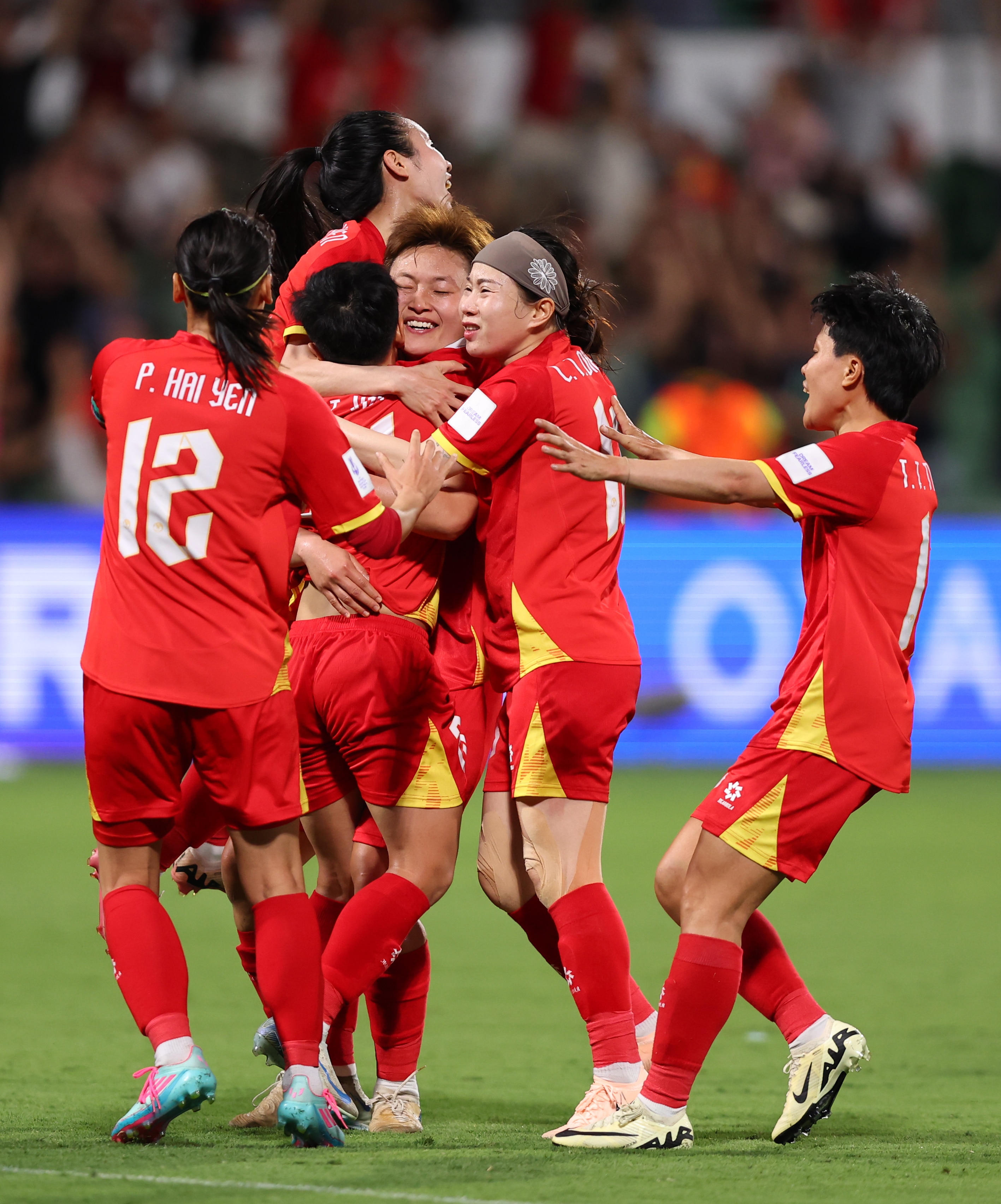 Jogadoras da seleção vietnamita de futebol feminino comemoram o gol.