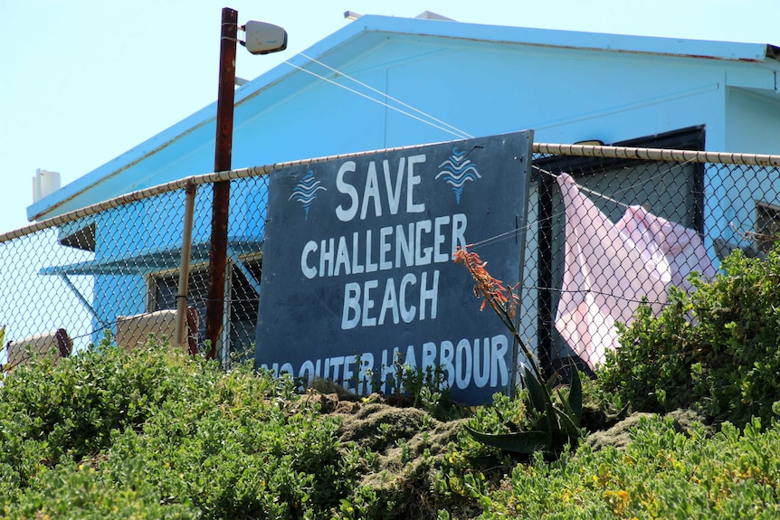 A sign protesting the development of a new port attached to a fence on a beach side shack on the Cockburn Sound