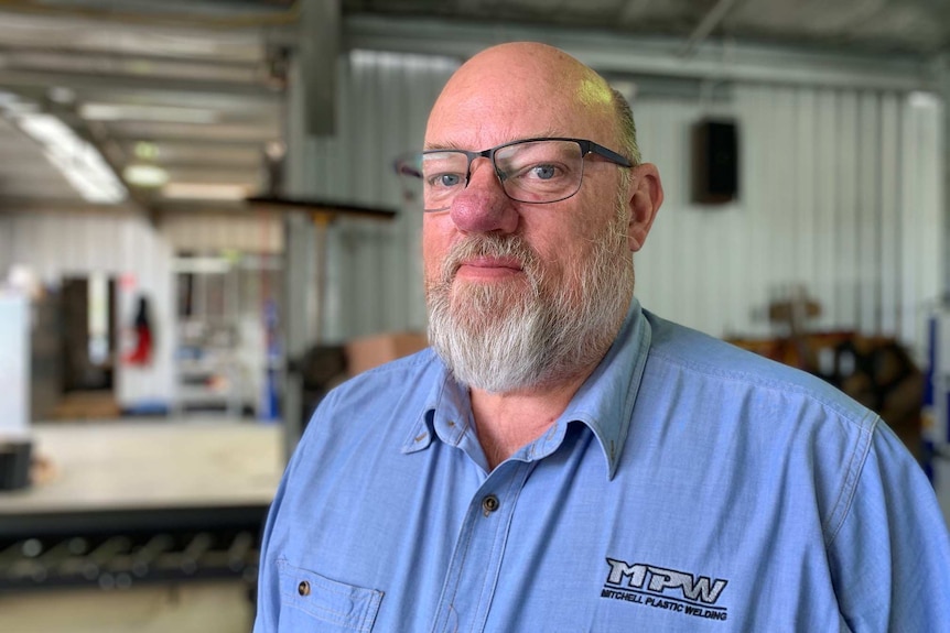 Michael Rowe stands in a factory.