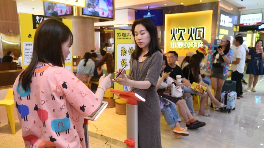 A customer is weighed before heading into a restaurant in China.