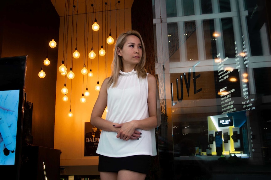 Roni Law stands inside her hair salon in Sydney.