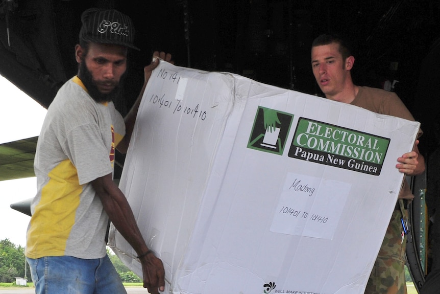 Australian soldier Ben Crawford helps a member of the PNG Election Office in 2012.