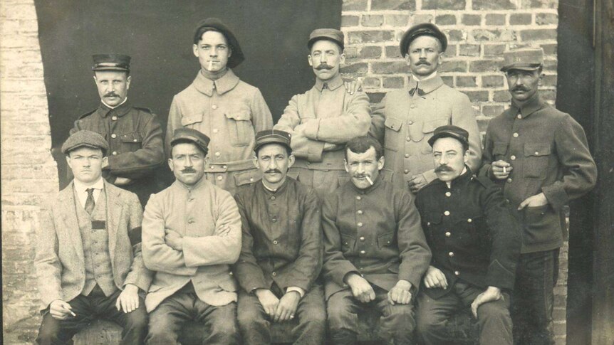 Black and white photo of nine men, some in French military uniform.