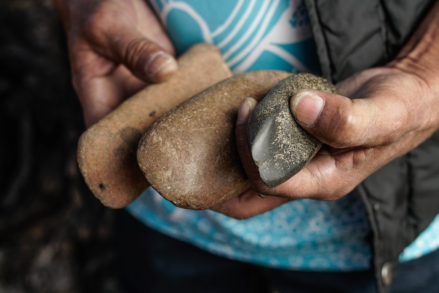 Steve Talbott holds Aboriginal artefacts