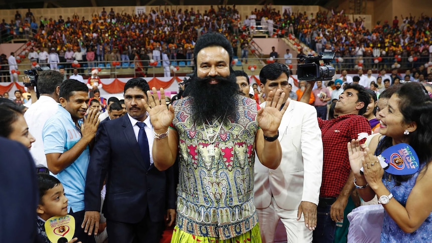 Indian spiritual guru who calls himself Saint Dr Gurmeet Ram Rahim Singh Ji Insan greets followers on the red carpet.