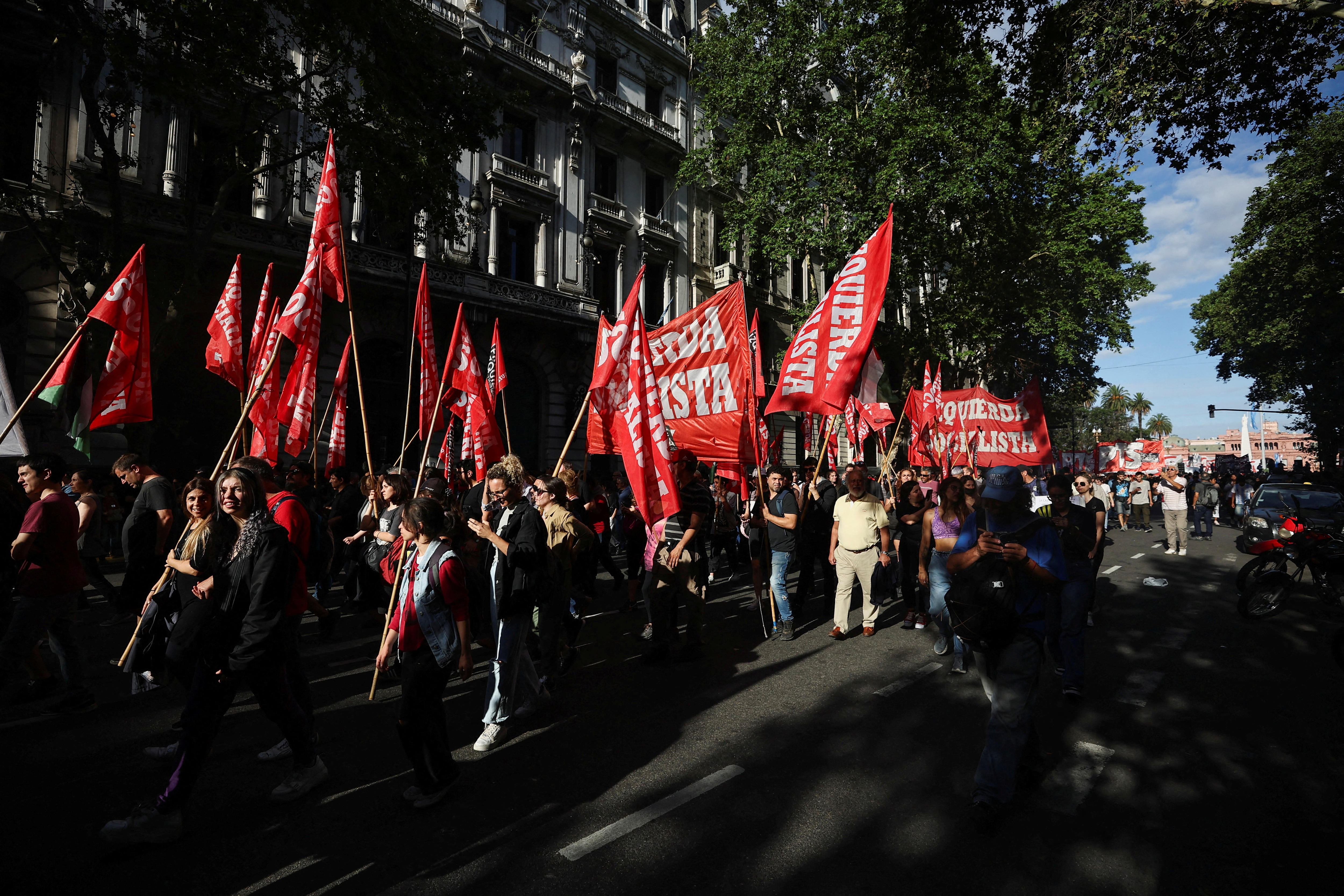 Protesters are pictured with red flags