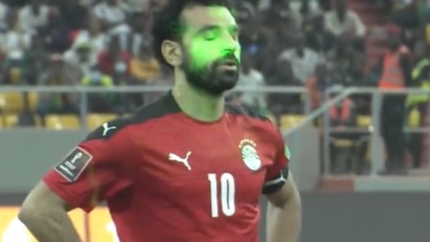 A man closes his eyes as laser pointers hit his face