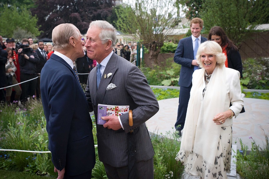 Prince Charles greets his father Prince Philip as Camilla and Prince Harry watch on.
