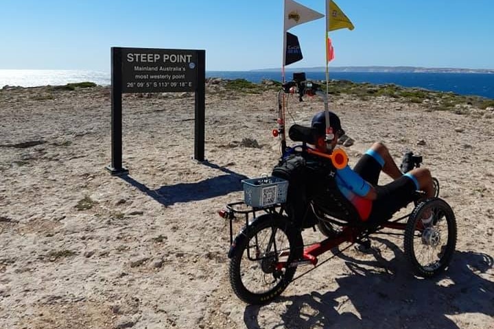 tommy quick on trike near steep point sign 
