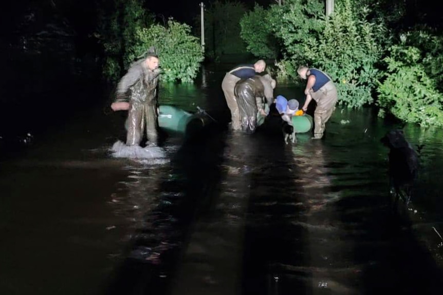 I servizi di emergenza salvano le persone da una zona allagata.