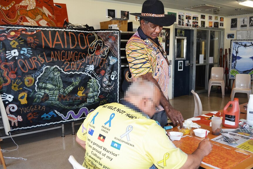 Indigenous artist Charlie Chambers teaches art to an unidentified prisoner at Southern Queensland Correctional Centre.