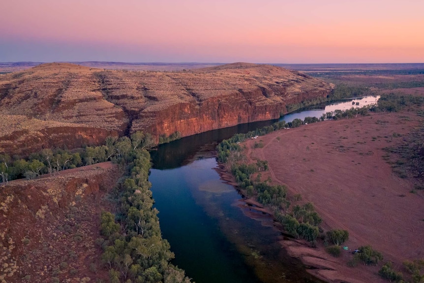 gorge and waterhole in the desert at sunset.