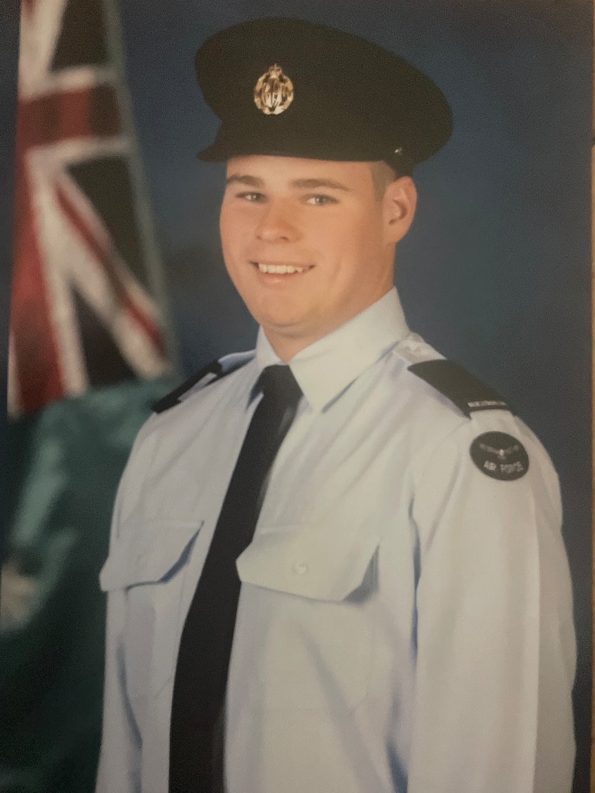 A man wearing an Air Force uniform consisting of a shirt and tie and hat.