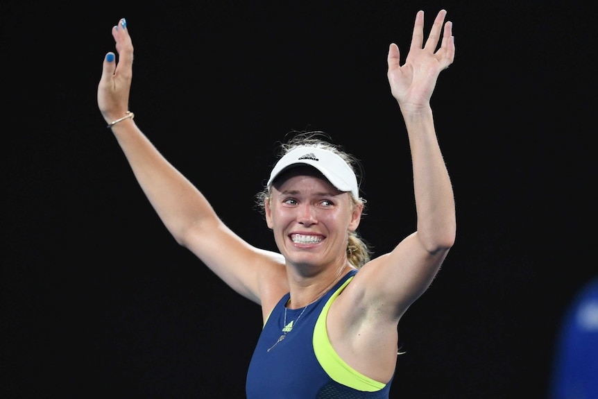 Caroline Wozniacki raises her arms in triumph after winning the Australian Open.