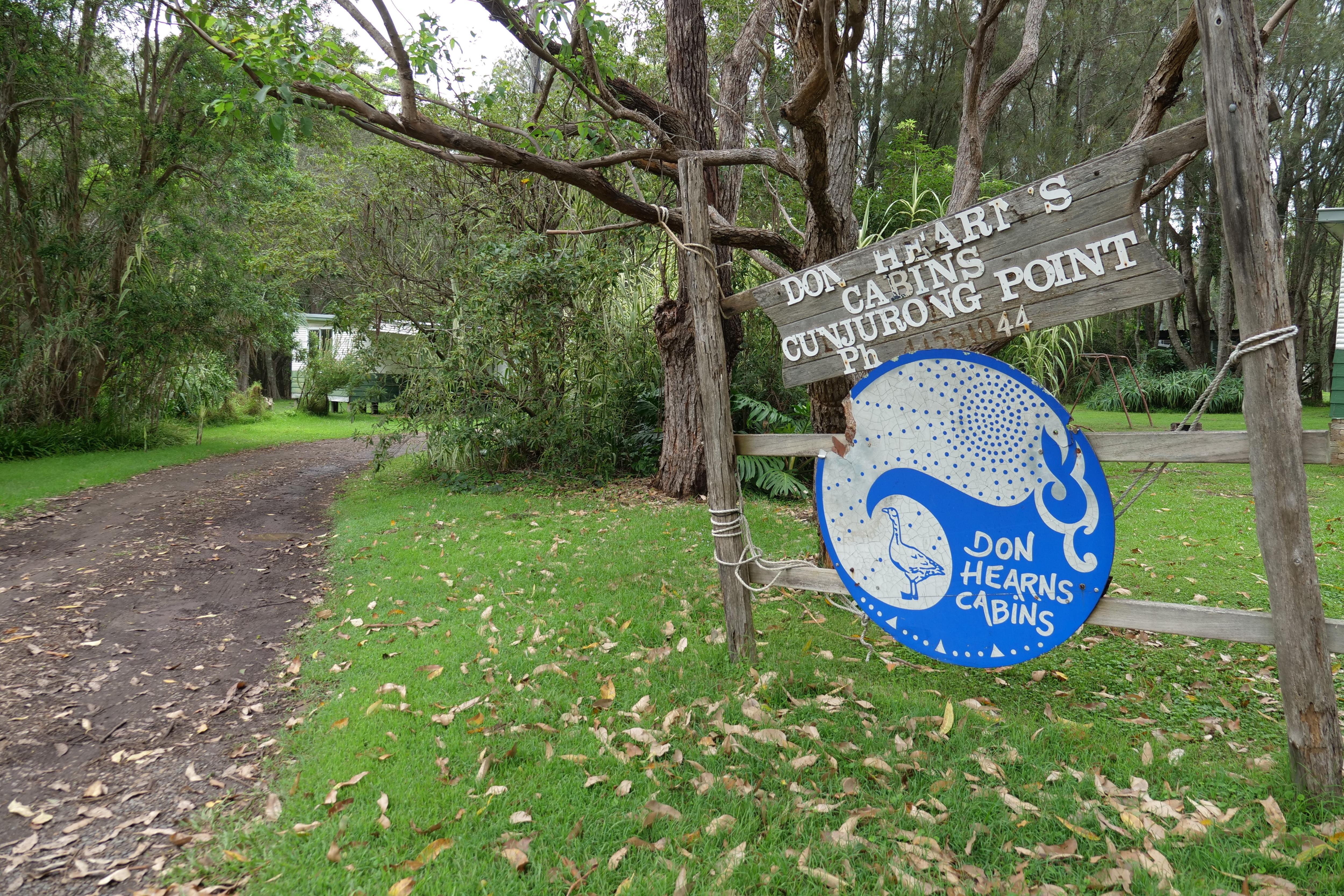 Wooden sign with blue and white paint standing out front of holiday park