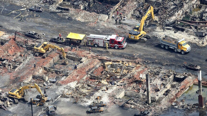 Workers and firefighters work in Lac Megantic after train explosion.