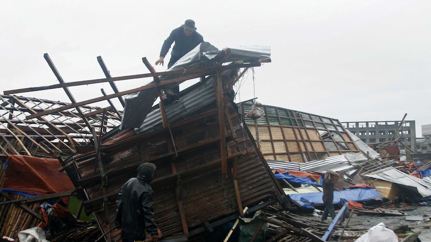 A man on top of his damaged house in Tacloban