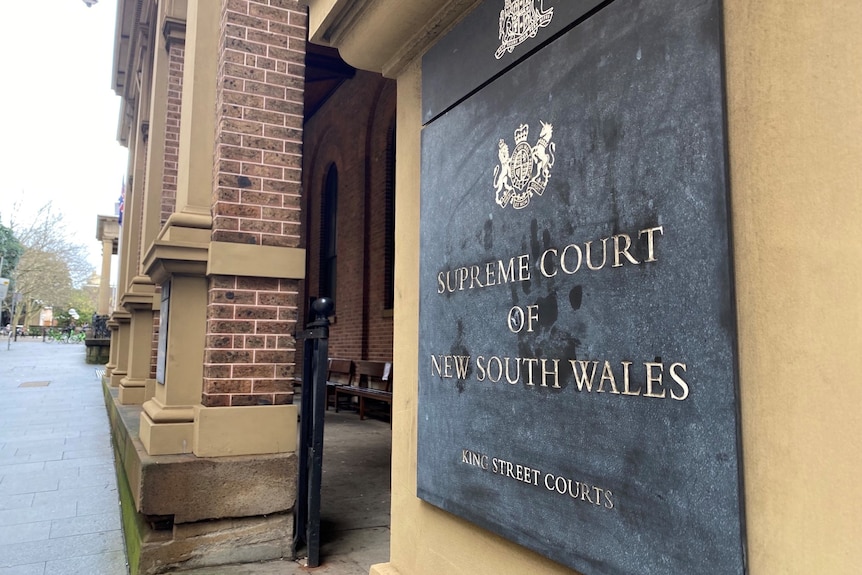 A plaque that says "Supreme Court of New South Wales" on the side on a historic-looking building.