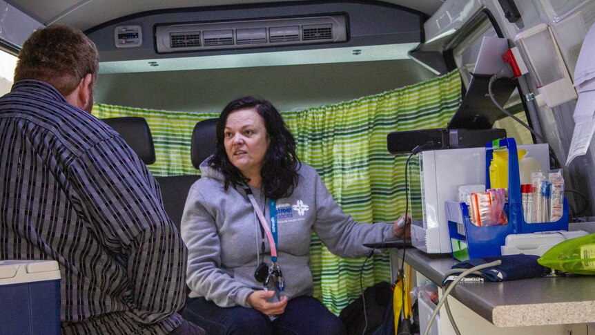 Dr Coles sees a patient inside the van.