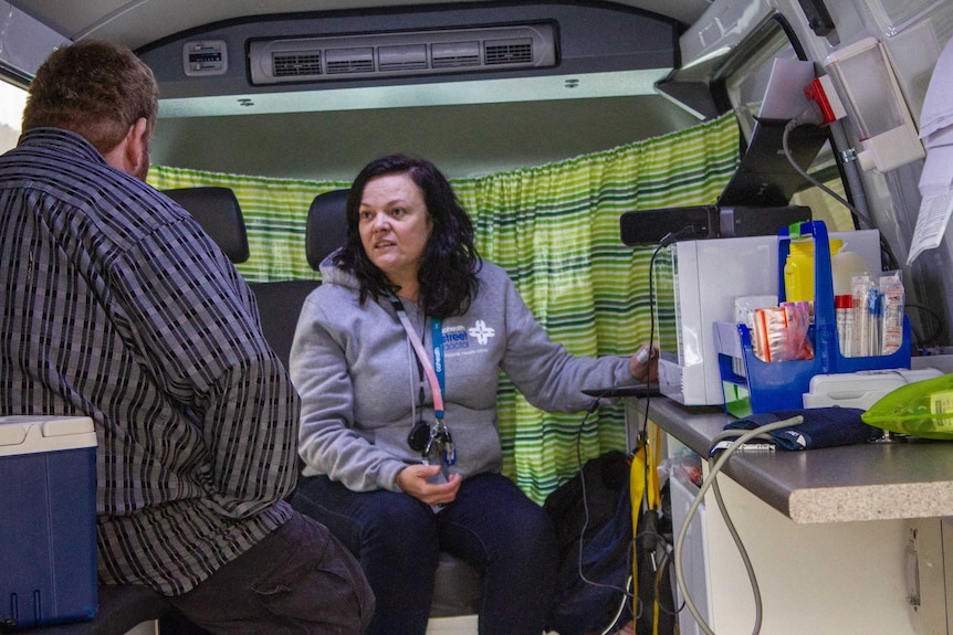 Dr Coles sees a patient inside the van.