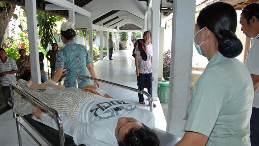 Nurses push a stretcher carrying a man injured during an earthquake in Denpasar on the island of Bal