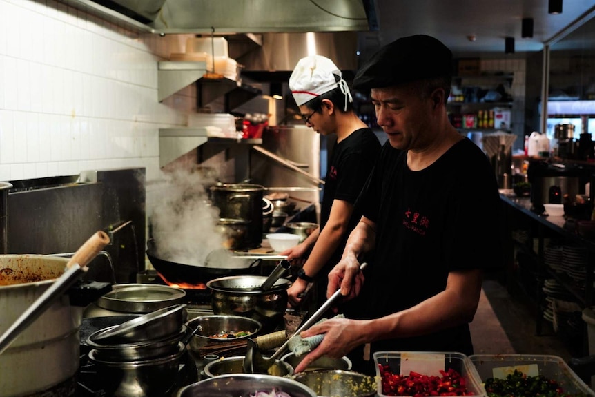 Two chefs cook in Chilli Panda's kitchen.
