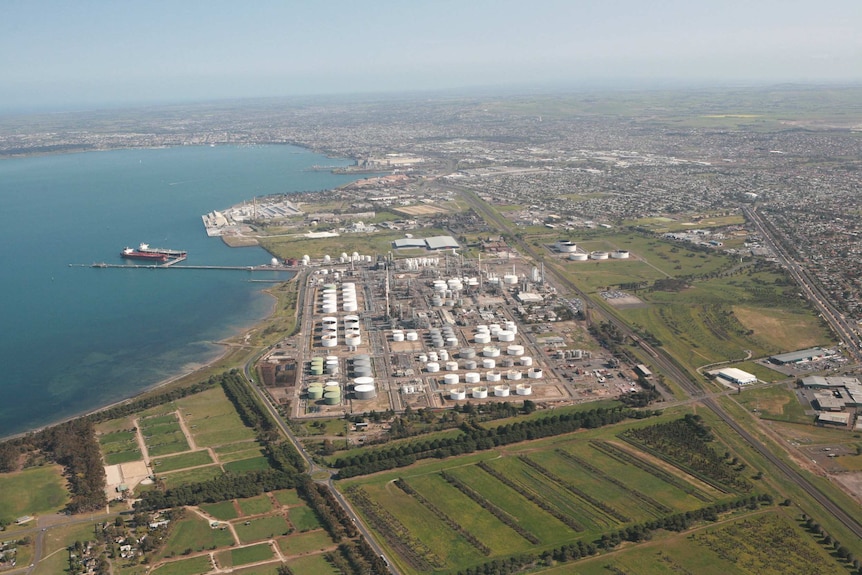an aerial view of an oil refinery on the coast