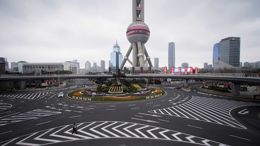 You view a wide shot of a large Shanghai intersection with a globe-like tower pictured behind it.