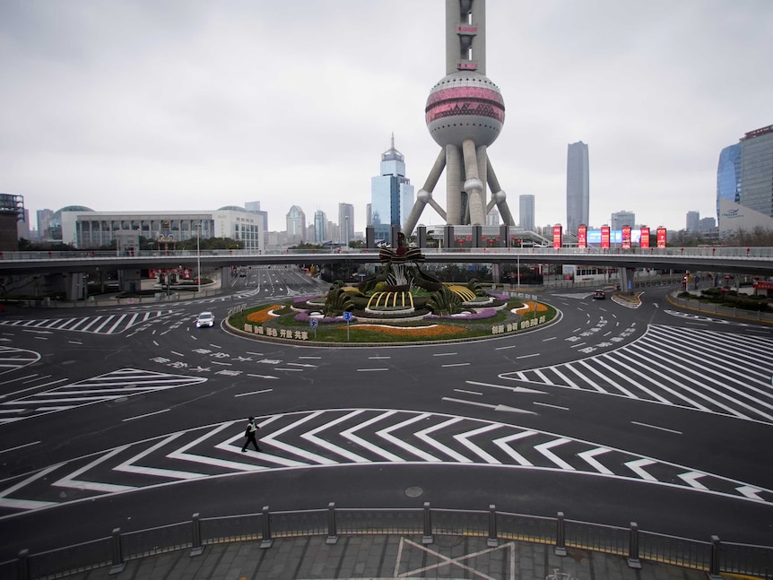 You view a wide shot of a large Shanghai intersection with a globe-like tower pictured behind it.